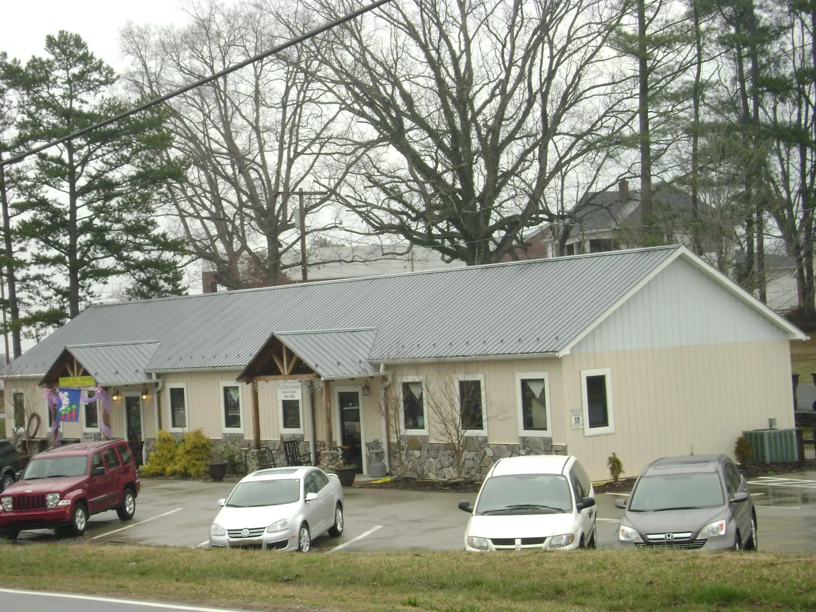 Gray metal roof with timber entry brackets on a small commercial building in Madison